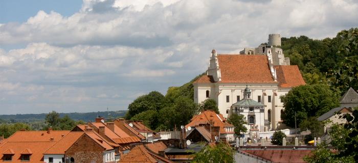 Kazimierz w pigułce: zabytkowe kamienice i zielone wzgórza, a w tle ruiny zamku.