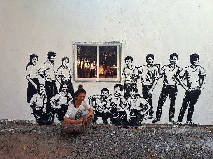 Asia przy muralu w Kambodży 